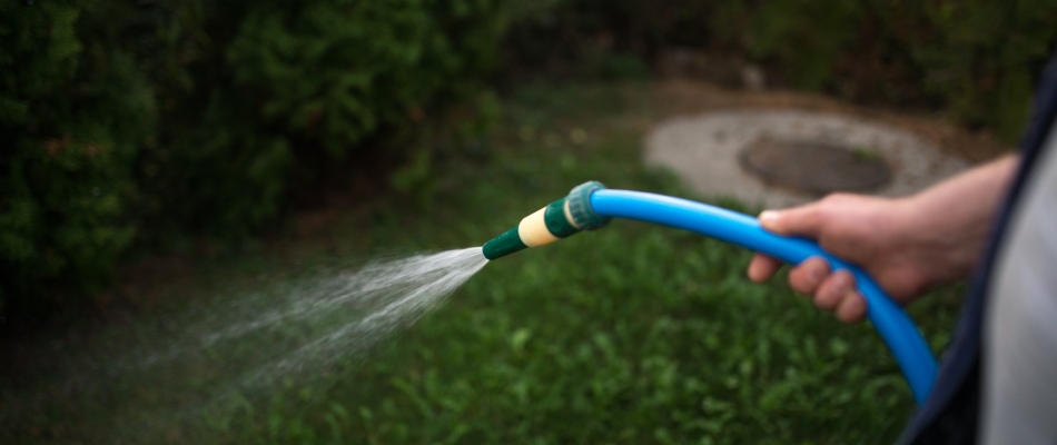 Professional spraying liquid fertilizer over lawn in Marquette, MI.